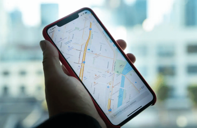 a hand holding a cell phone with a map on it